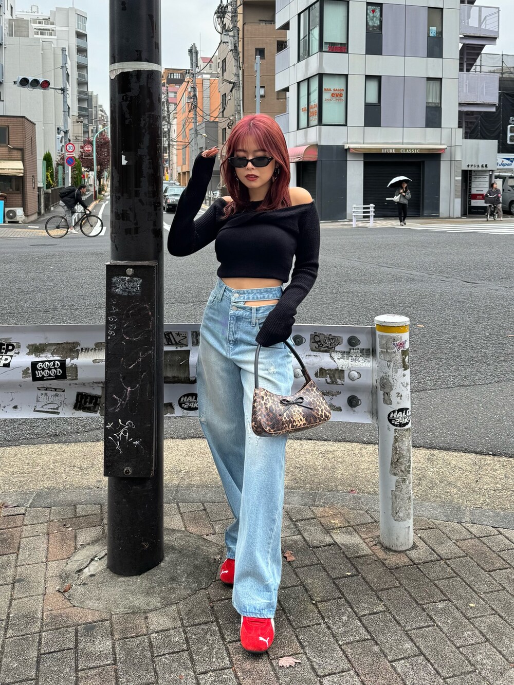 ブルー系のデニムパンツ、ブラック系のニット/セーター、レッド系のスニーカーを着用したレディースの冬コーディネートの2枚目の写真