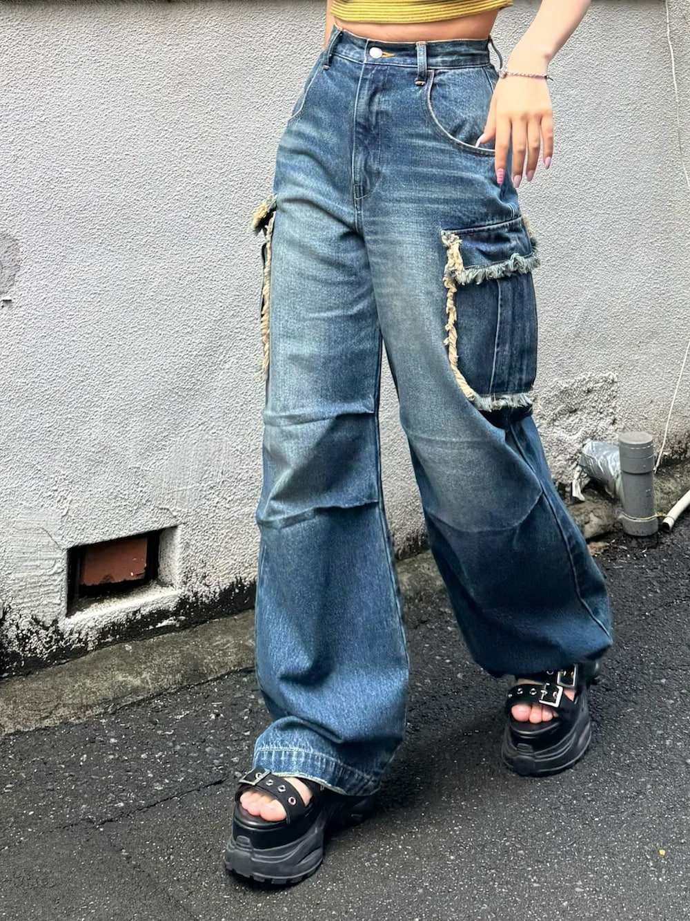 ブルー系のデニムパンツ、イエロー系のTシャツ/カットソー、ブラック系のサンダルを着用したレディースの春コーディネートの3枚目の写真