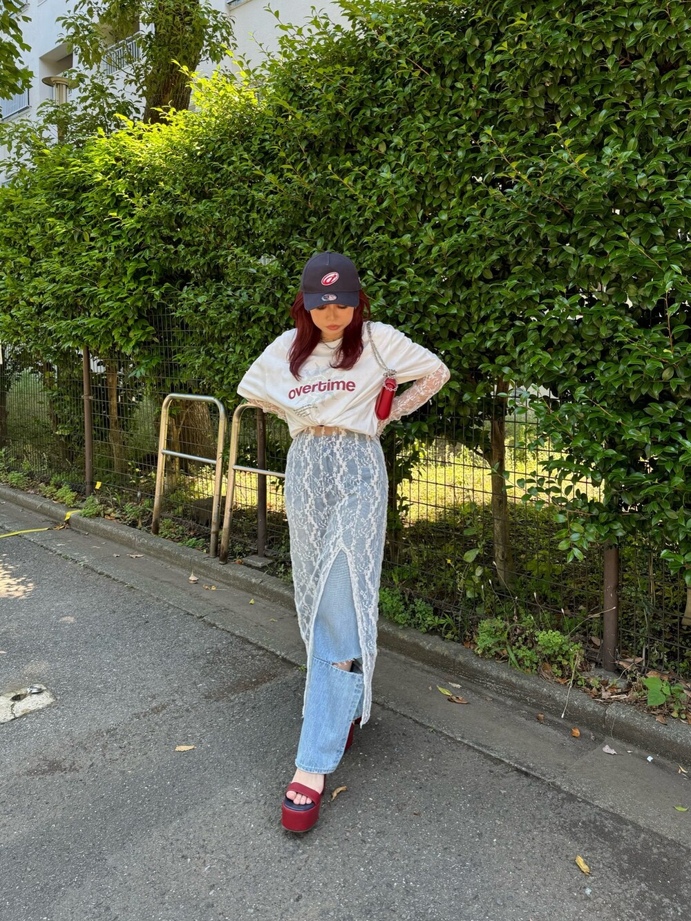 ホワイト系のワンピース、ブルー系のデニムパンツ、レッド系のサンダルを着用したレディースの夏コーディネートの2枚目の写真
