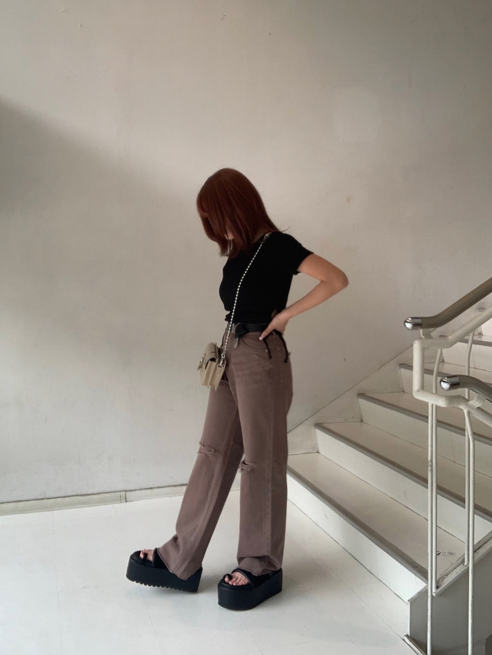 ブラック系のTシャツ/カットソー、ブラック系のサンダル、ブラウン系のデニムパンツを着用したレディースの夏コーディネートの2枚目の写真