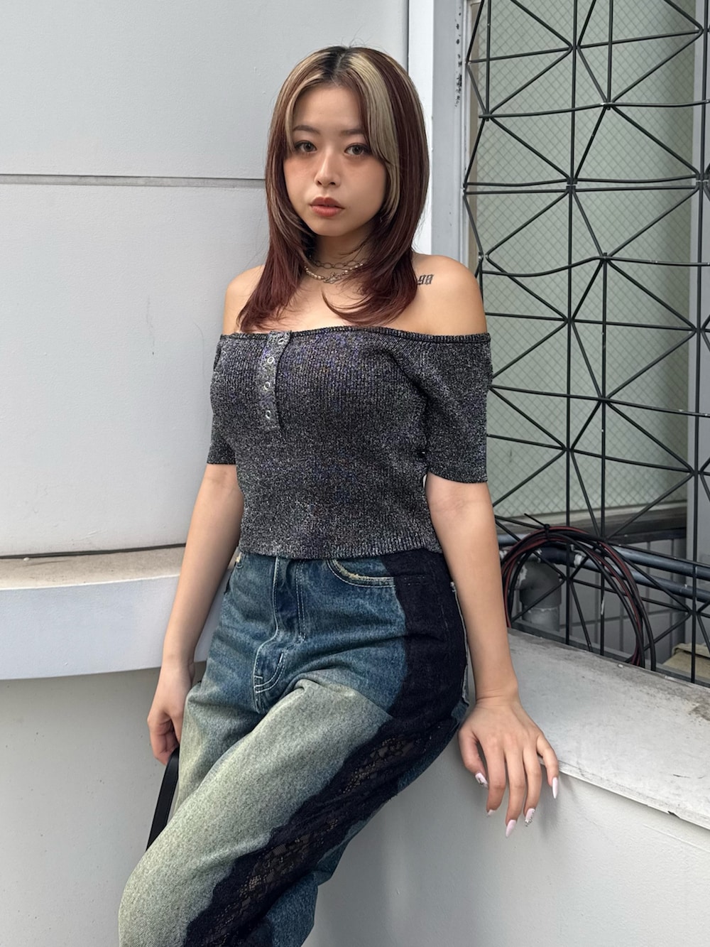 ブラック系のニット/セーター、ブルー系のデニムパンツ、ブラック系のハンドバッグを着用したレディースの春コーディネートの4枚目の写真