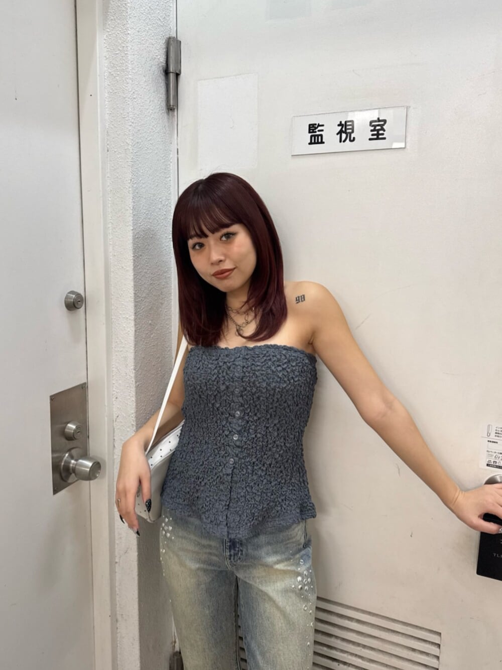 グレー系のキャミソール、ブルー系のデニムパンツ、ピンク系のサンダルを着用したレディースの春コーディネートの4枚目の写真