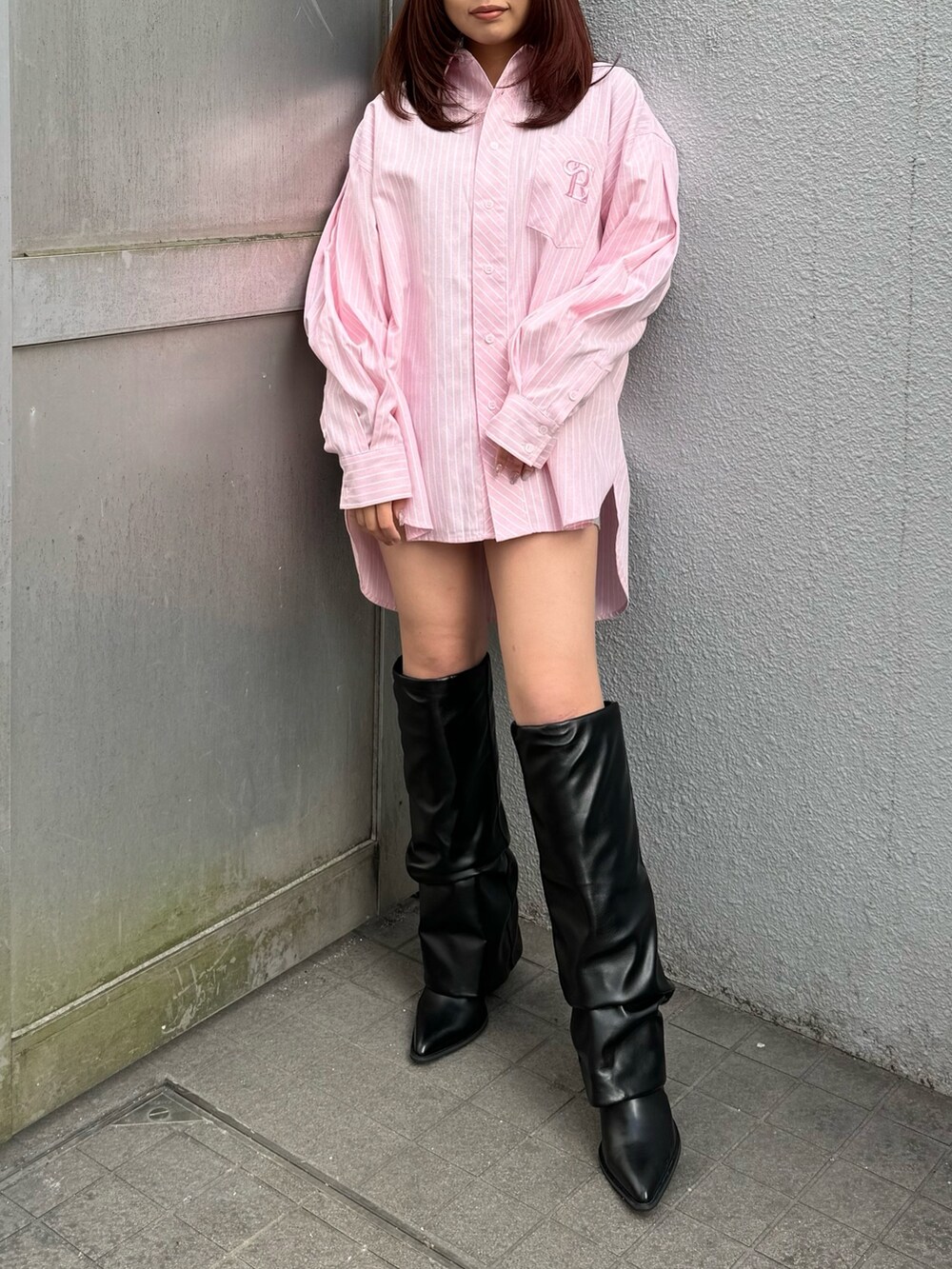 ピンク系のシャツ/ブラウス、ブラック系のブーツを着用したレディースの冬コーディネートの2枚目の写真