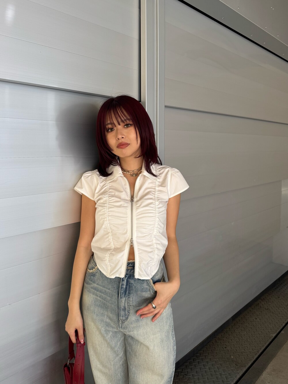 ホワイト系のシャツ/ブラウス、ブルー系のデニムパンツ、レッド系のショルダーバッグを着用したレディースの春コーディネートの5枚目の写真