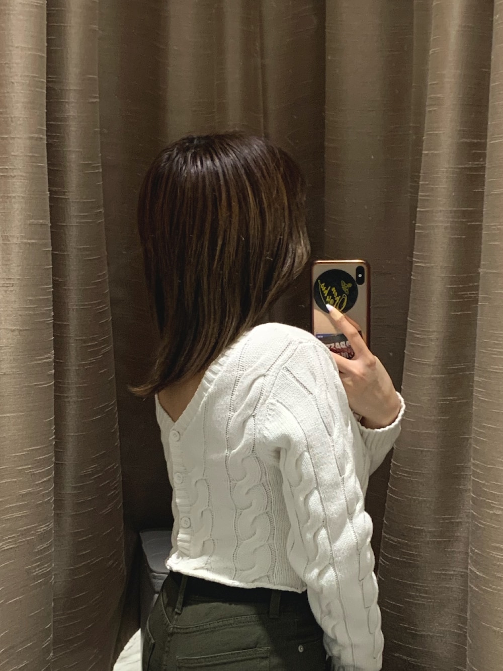 ホワイト系のカーディガン/ボレロ、グリーン系のデニムパンツ、ブラック系のブーツを着用したレディースの冬コーディネートの3枚目の写真