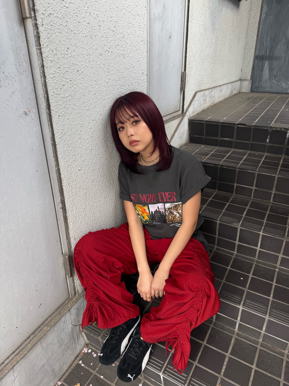 ブラック系のTシャツ/カットソー、ブラック系のショルダーバッグ、レッド系のその他パンツを着用したレディースの春コーディネートの3枚目の写真