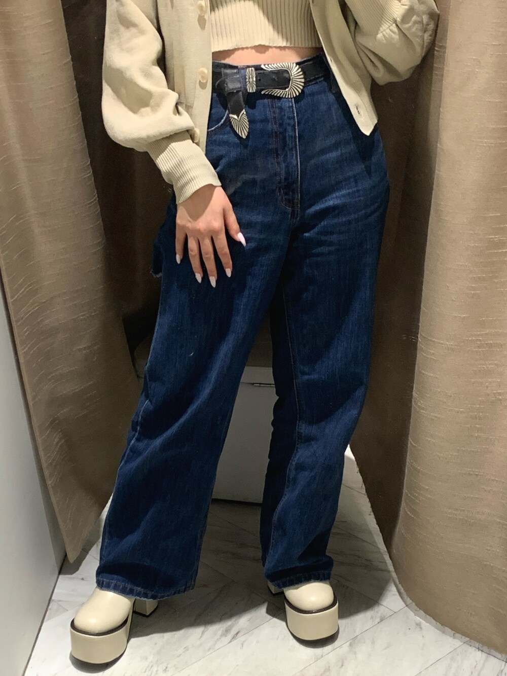 ブルー系のデニムパンツ、ホワイト系のカーディガン/ボレロ、ホワイト系のブーツを着用したレディースの冬コーディネートの5枚目の写真