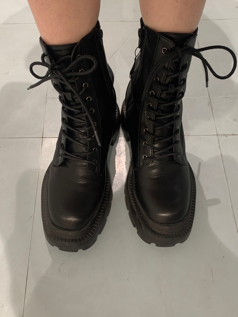 ホワイト系のTシャツ/カットソー、ホワイト系のハンドバッグ、ブラック系のブーツを着用したレディースの春コーディネートの7枚目の写真