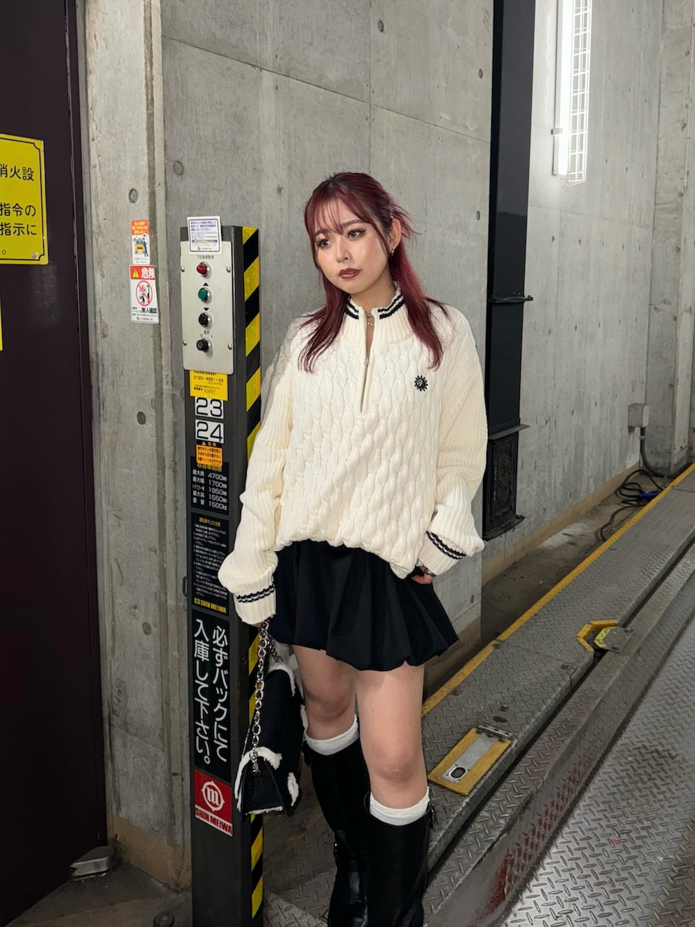 ホワイト系のニット/セーター、ブラック系のスカート、ブラック系のブーツを着用したレディースの夏コーディネートの3枚目の写真