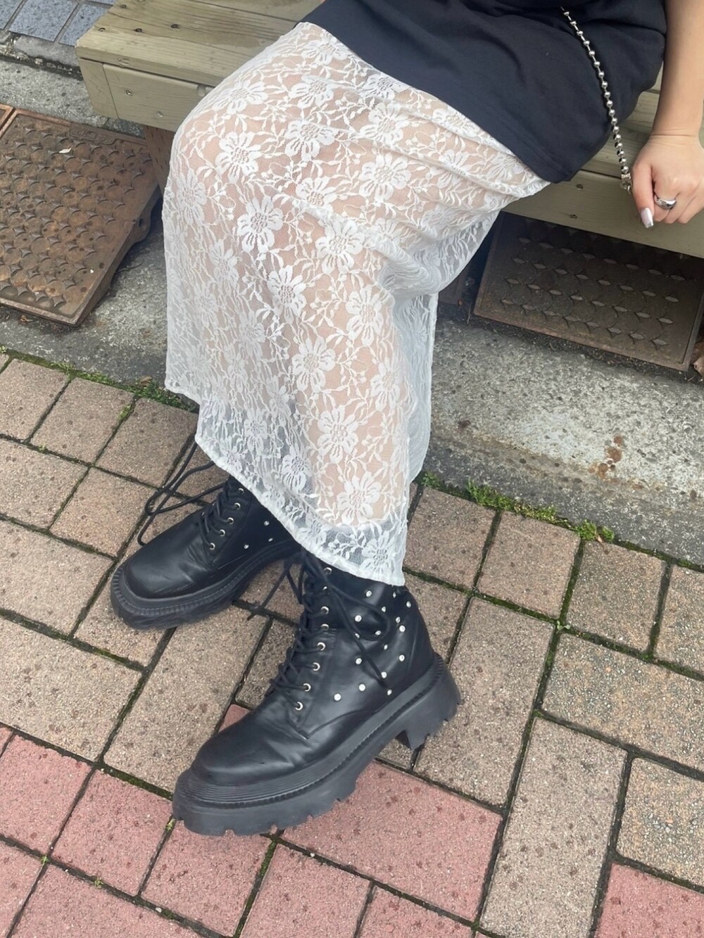 ブラック系のTシャツ/カットソー、ホワイト系のスカート、ブラック系のブーツを着用したレディースの春コーディネートの3枚目の写真