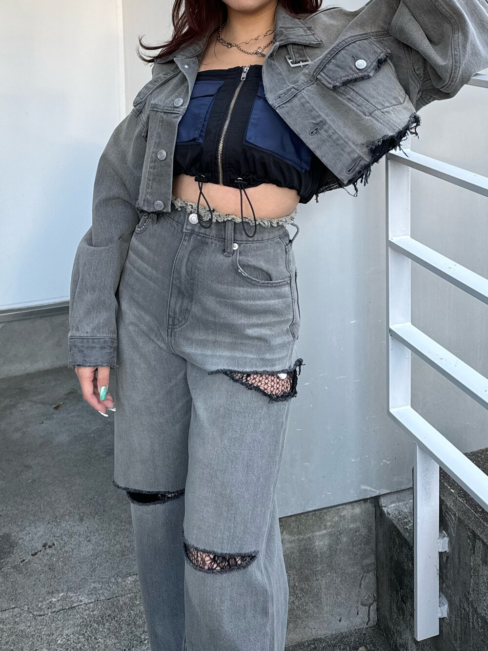 ブラック系のデニムパンツ、ブラック系のキャミソール、ブラック系のデニムジャケットを着用したレディースの冬コーディネートの3枚目の写真