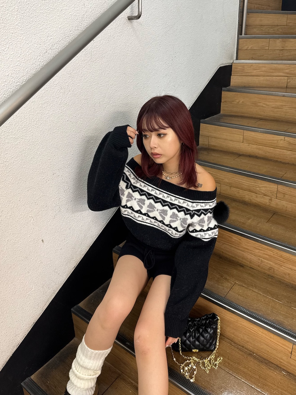 ブラック系のニット/セーター、ブラック系のその他パンツ、ブラック系のショルダーバッグを着用したレディースの秋コーディネートの5枚目の写真