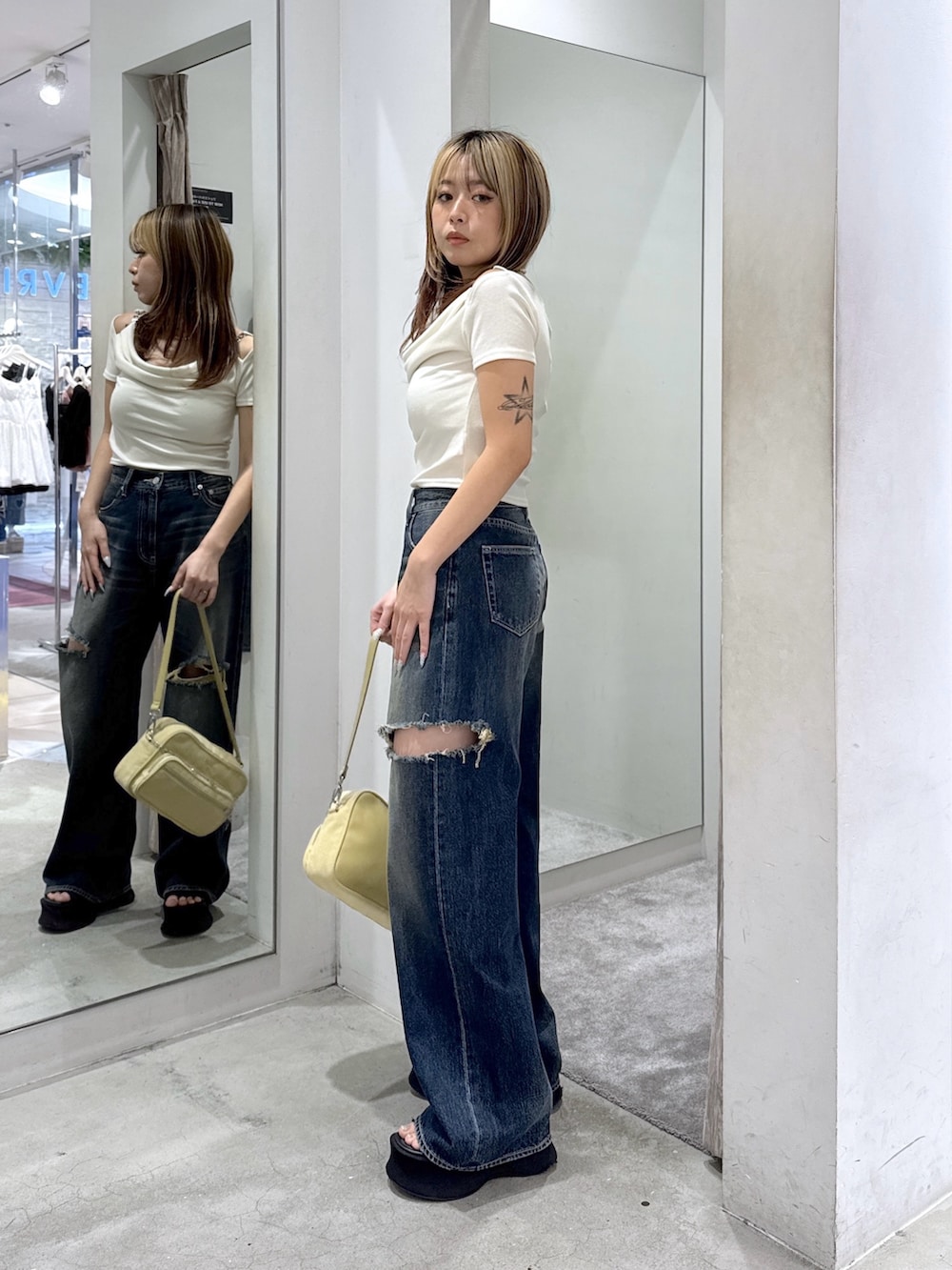 ホワイト系のTシャツ/カットソー、ブルー系のデニムパンツ、イエロー系のハンドバッグを着用したレディースの夏コーディネートの2枚目の写真