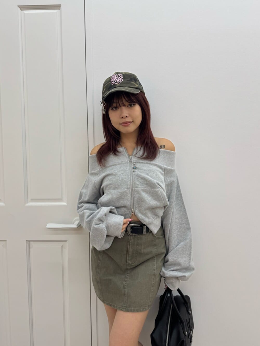 ブラック系のボストンバッグ、ブラック系のブーツ、グレー系のスウェットを着用したレディースの冬コーディネートの4枚目の写真