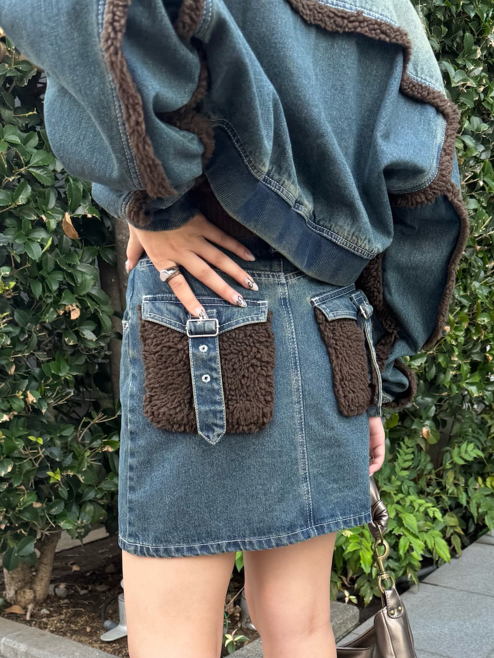 ブルー系のブルゾン、ブルー系のニット/セーター、ブルー系のデニムスカートを着用したレディースの秋コーディネートの6枚目の写真