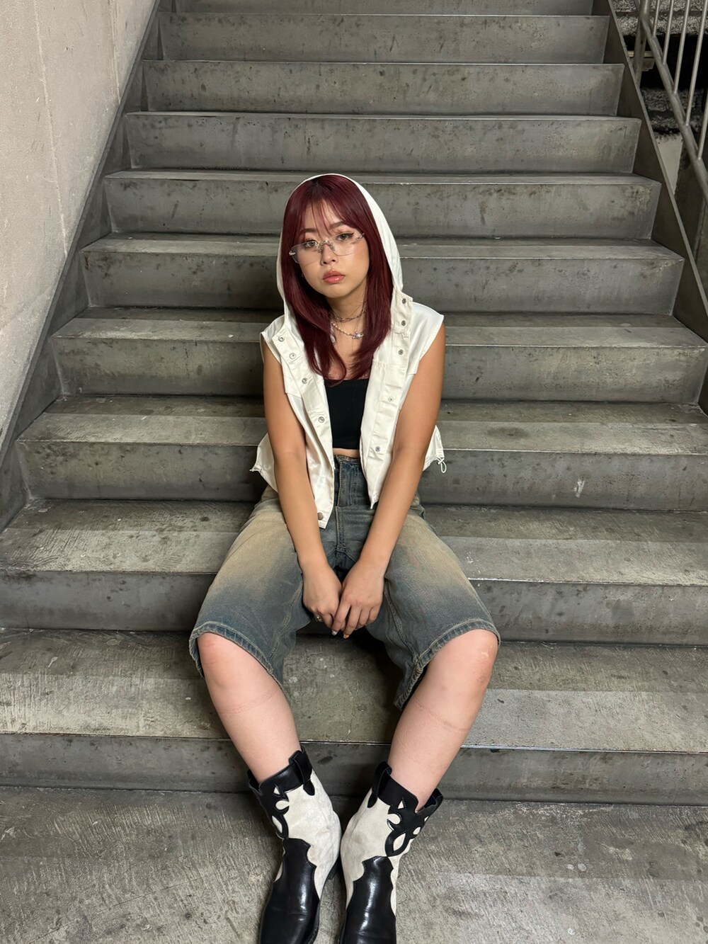 ホワイト系のベストを着用したレディースの夏コーディネートの2枚目の写真