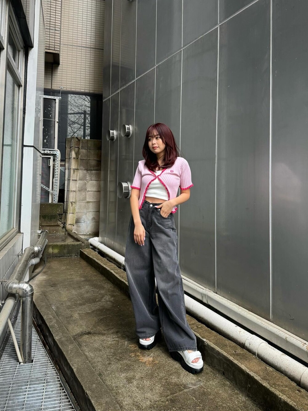 ホワイト系のキャミソール、ピンク系のカーディガン/ボレロ、ブラック系のデニムパンツを着用したレディースの春コーディネートの2枚目の写真