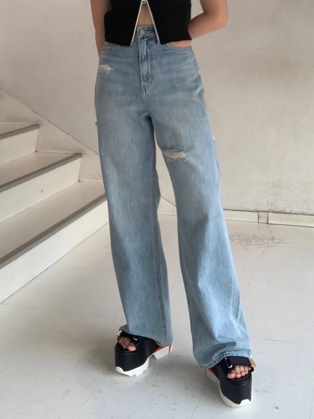 ブラック系のタンクトップ、ブルー系のデニムパンツ、オレンジ系のショルダーバッグを着用したレディースの夏コーディネートの6枚目の写真