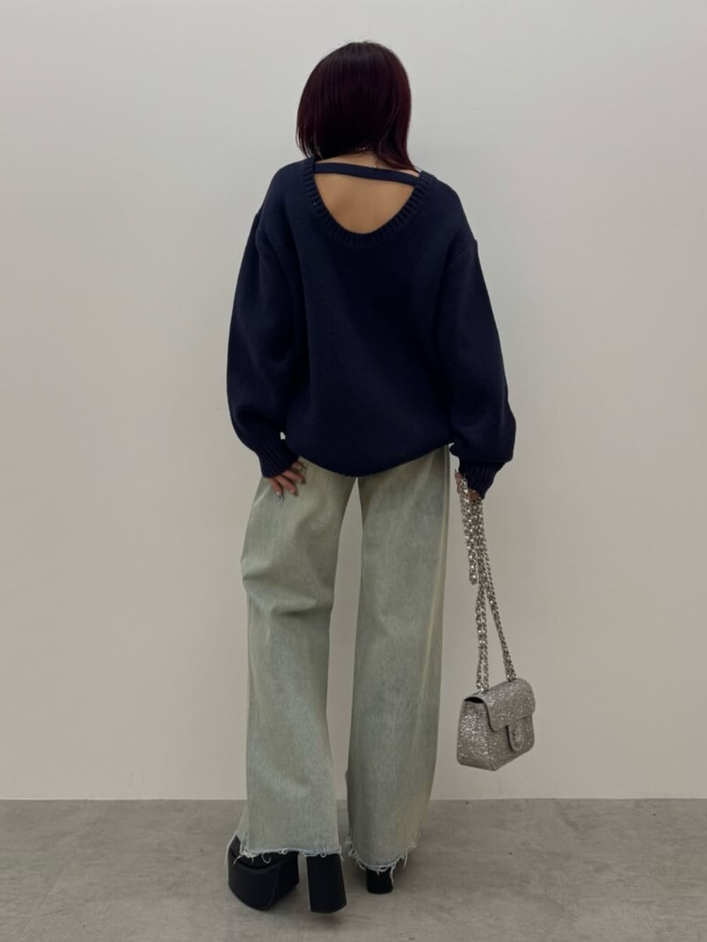 ブラック系のブーツ、ブルー系のニット/セーター、ブルー系のデニムパンツを着用したレディースの冬コーディネートの3枚目の写真