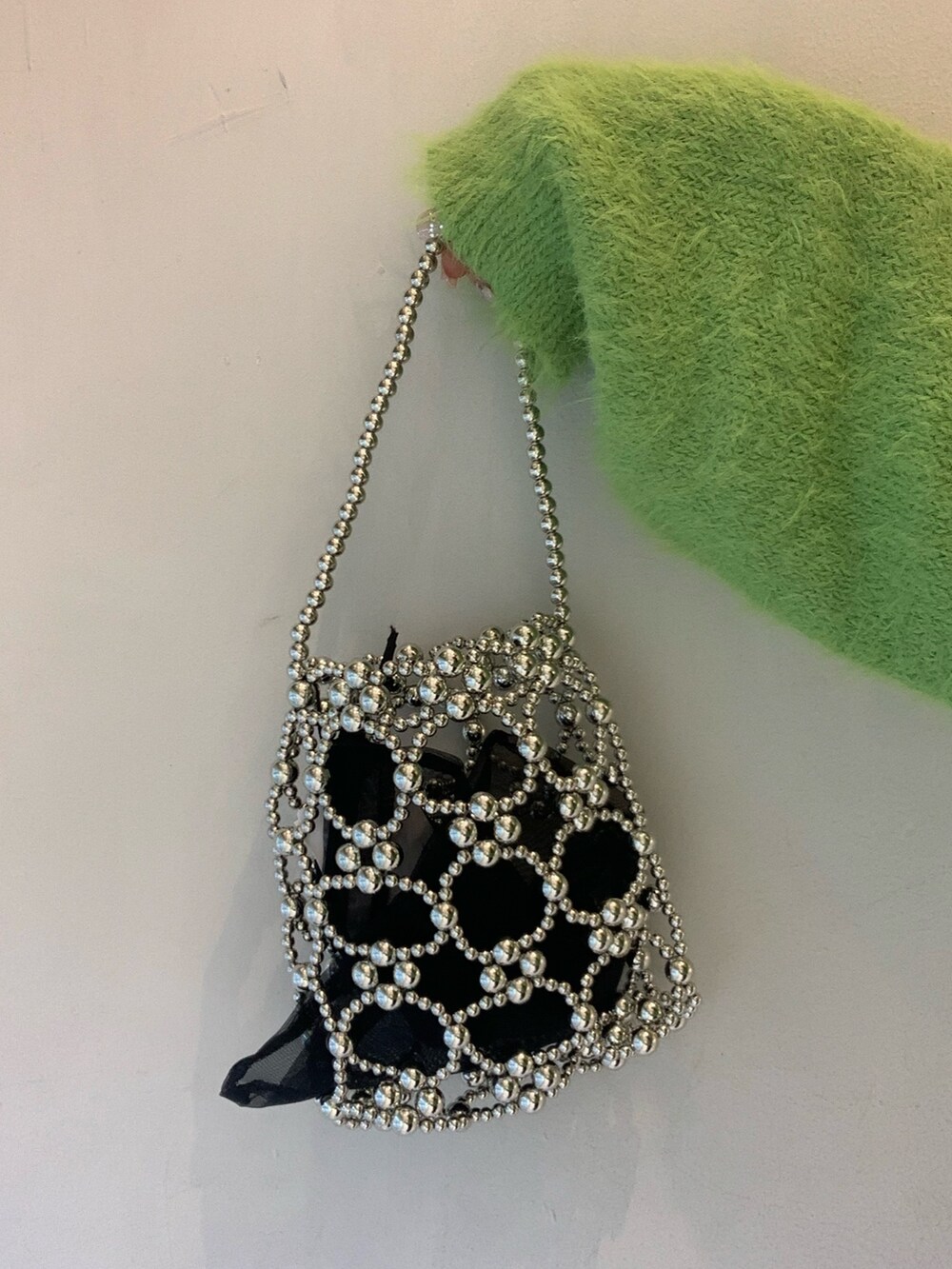 グリーン系のニット/セーター、ブラック系のその他パンツ、ブラック系のスリッポンを着用したレディースの冬コーディネートの7枚目の写真