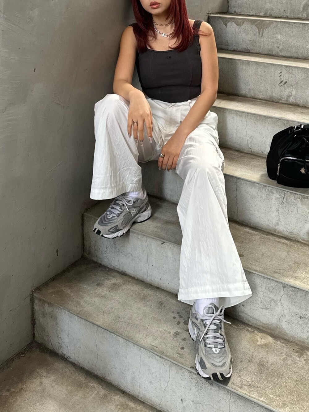 グレー系のキャミソール、ホワイト系のカーゴパンツ、ブラック系のショルダーバッグを着用したレディースの春コーディネートの3枚目の写真