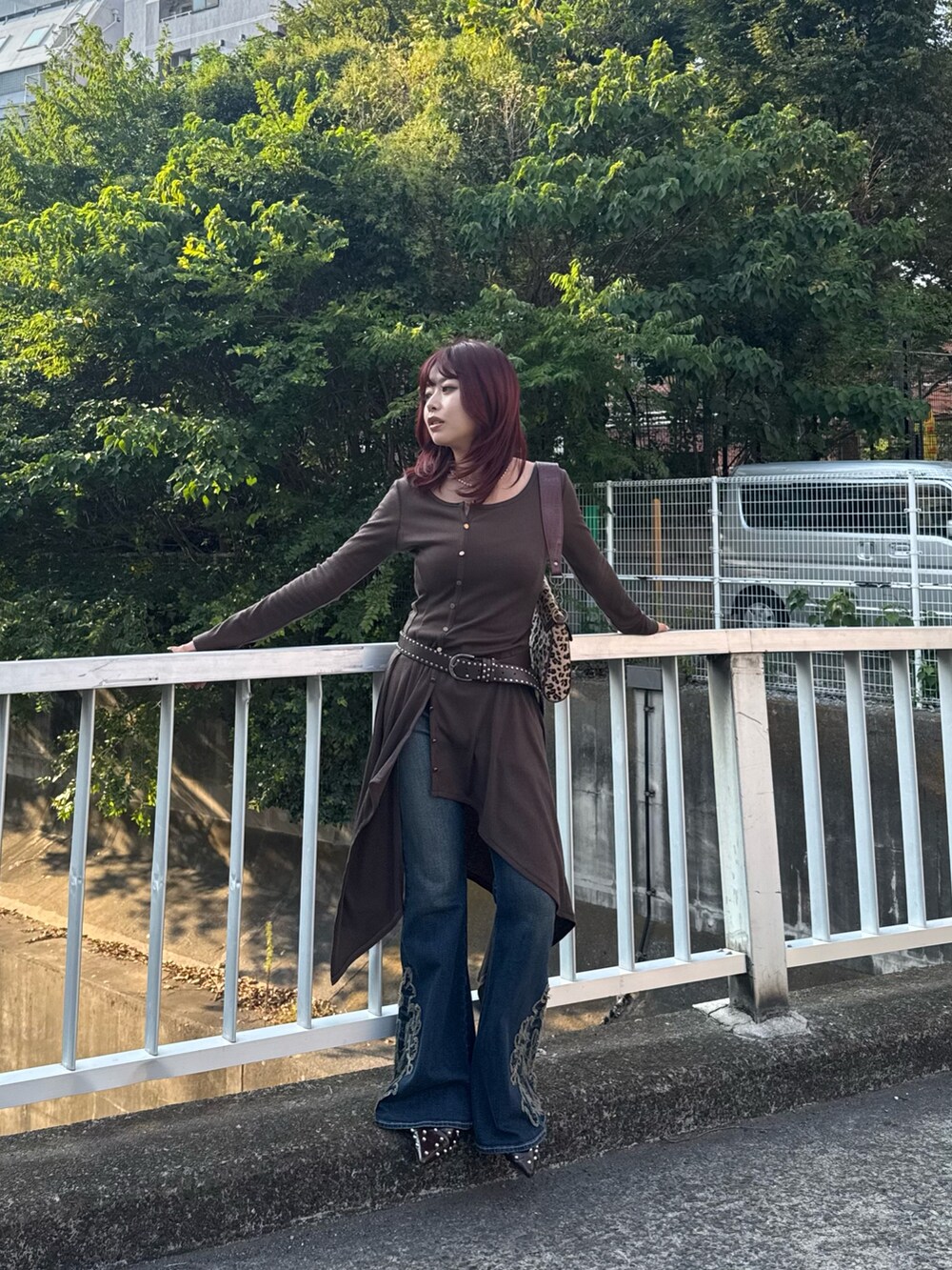 ブルー系のデニムパンツ、ベージュ系のハンドバッグを着用したレディースの秋コーディネートの2枚目の写真