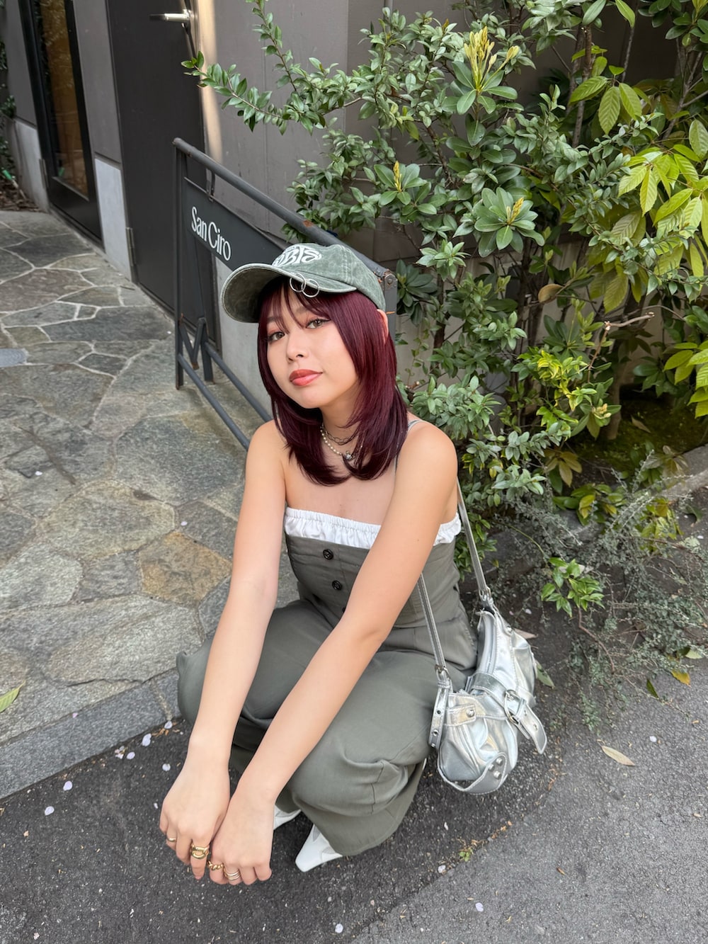 グリーン系のつなぎ/オールインワン、ホワイト系のパンプス、グリーン系のキャップを着用したレディースの春コーディネートの4枚目の写真