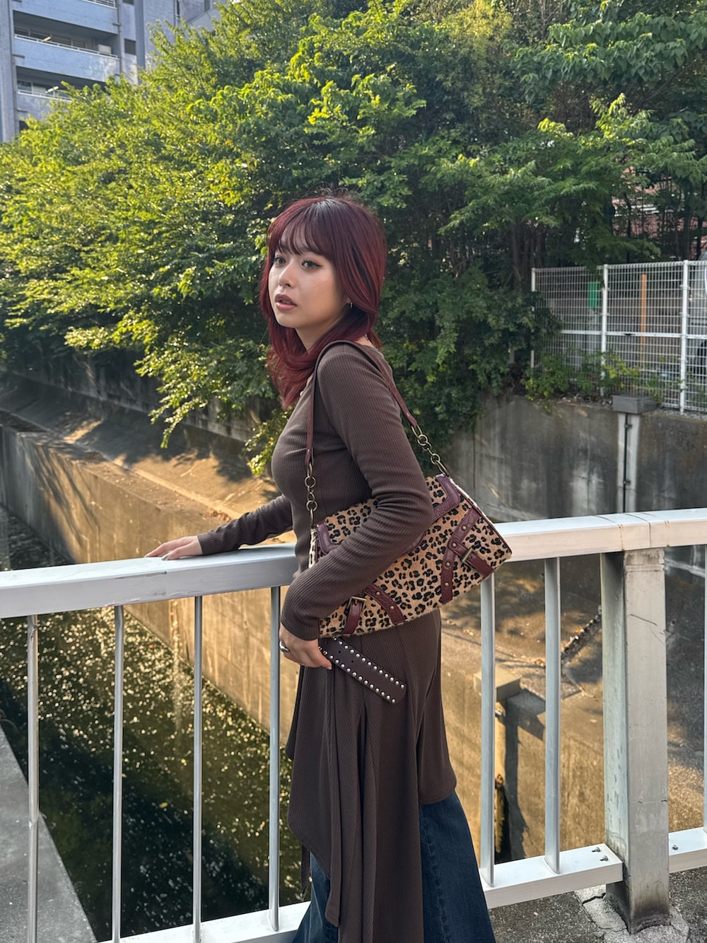 ブルー系のデニムパンツ、ベージュ系のハンドバッグを着用したレディースの秋コーディネートの5枚目の写真