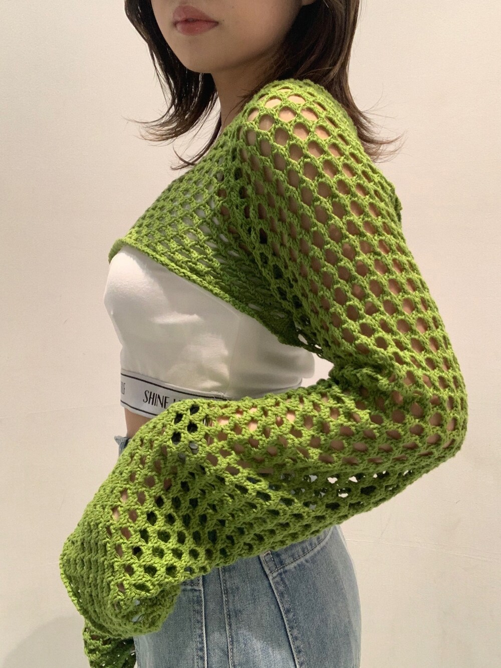 ホワイト系のサンダル、ブルー系のデニムパンツ、ホワイト系のキャミソールを着用したレディースの春コーディネートの3枚目の写真