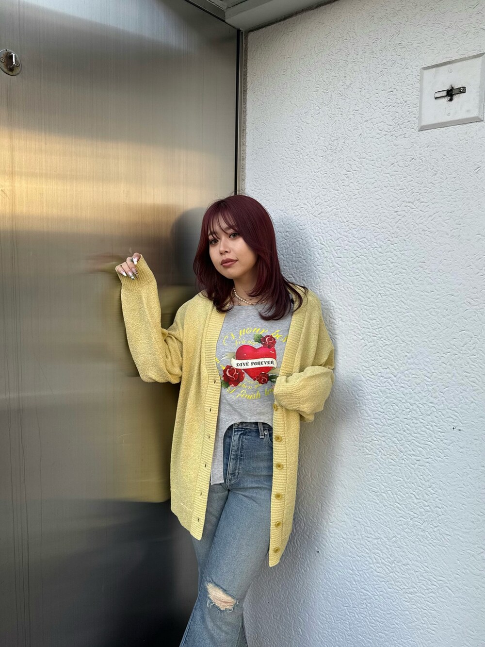 ブラック系のTシャツ/カットソー、イエロー系のカーディガン/ボレロ、ブルー系のデニムパンツを着用したレディースの春コーディネートの3枚目の写真