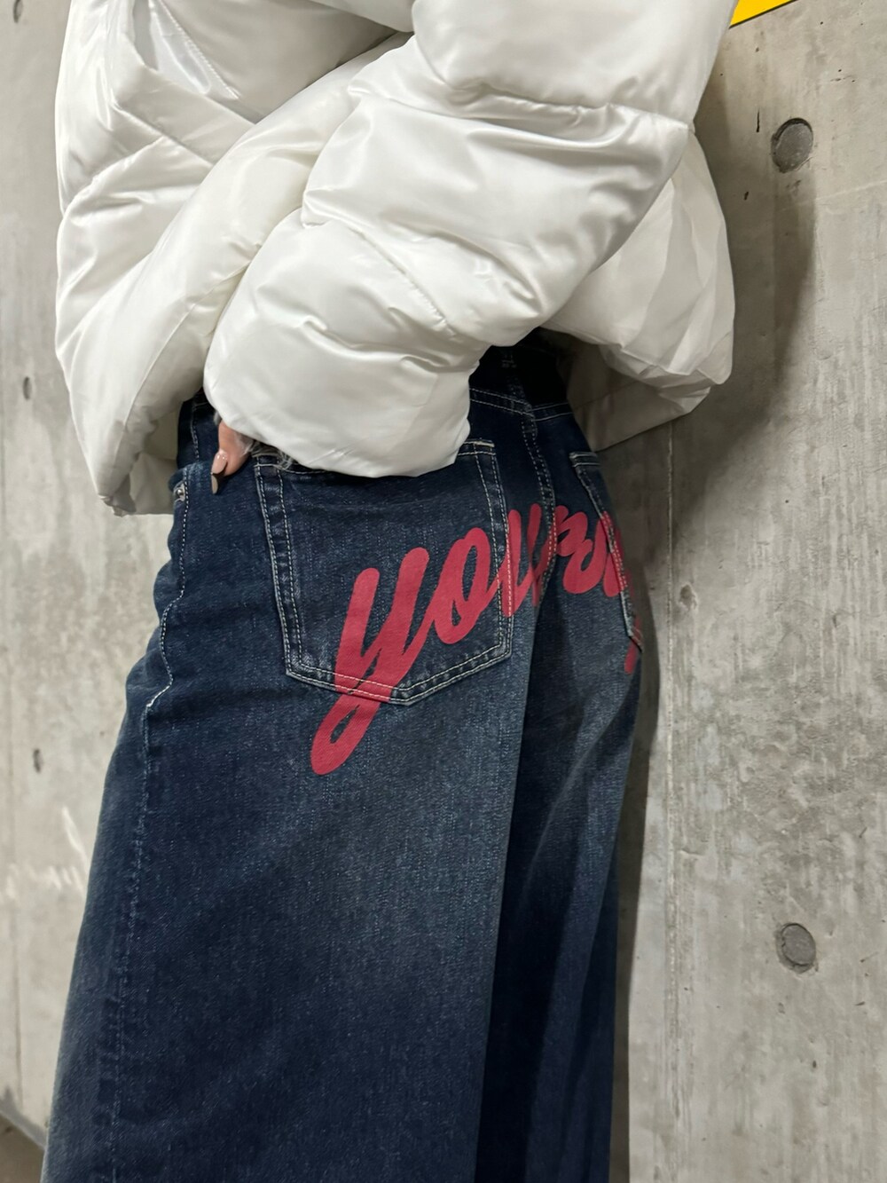 グレー系のニット/セーター、ホワイト系のブルゾン、ブルー系のデニムパンツを着用したレディースの秋コーディネートの5枚目の写真