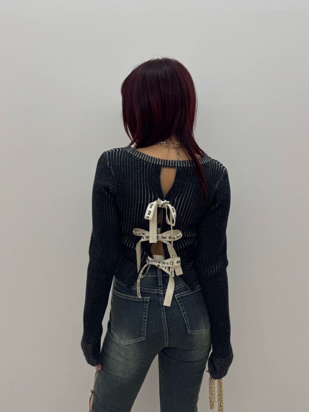 ブラック系のブーツ、ブラック系のニット/セーター、ブルー系のデニムパンツを着用したレディースの冬コーディネートの5枚目の写真