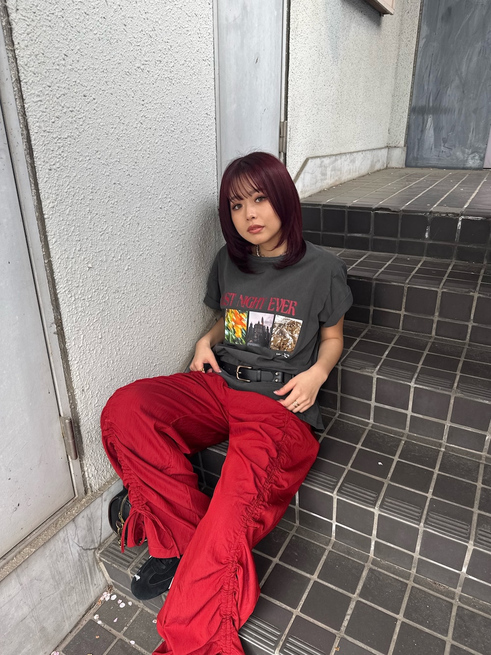 ブラック系のTシャツ/カットソー、ブラック系のショルダーバッグ、レッド系のその他パンツを着用したレディースの春コーディネートの4枚目の写真
