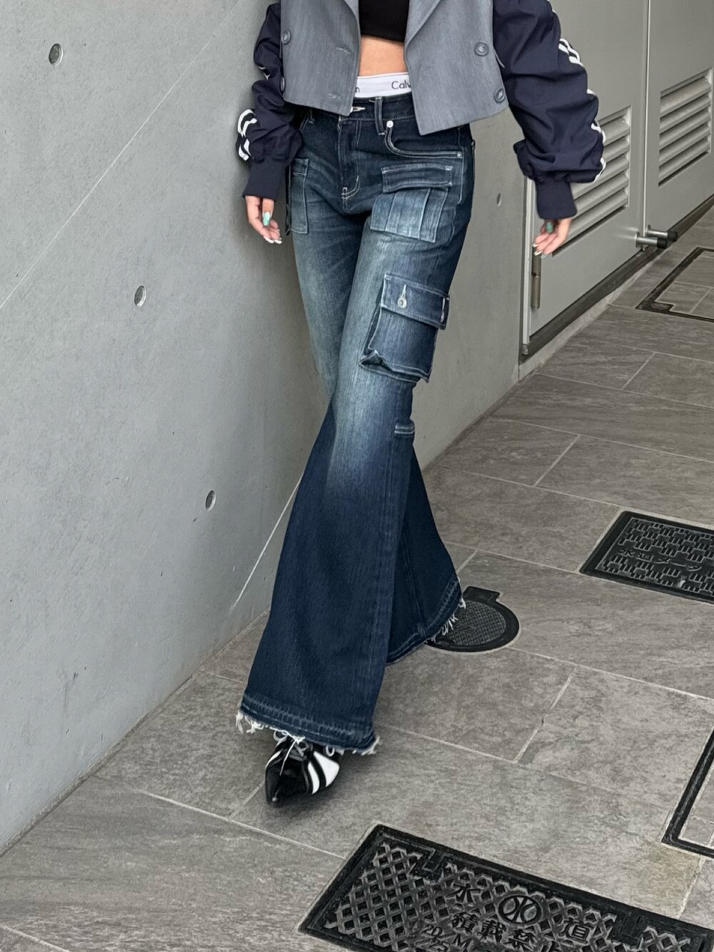 グレー系のテーラードジャケット、ブルー系のデニムパンツ、ブラック系のサンダルを着用したレディースの冬コーディネートの3枚目の写真