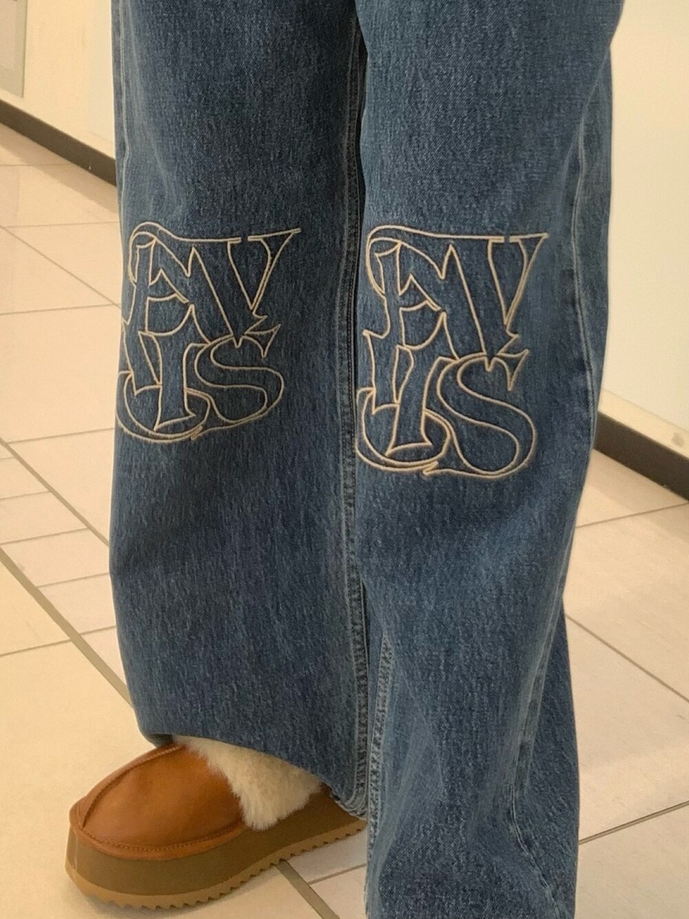 ホワイト系のダウンベスト、ホワイト系のニット/セーター、ブルー系のデニムパンツを着用したレディースの秋コーディネートの6枚目の写真