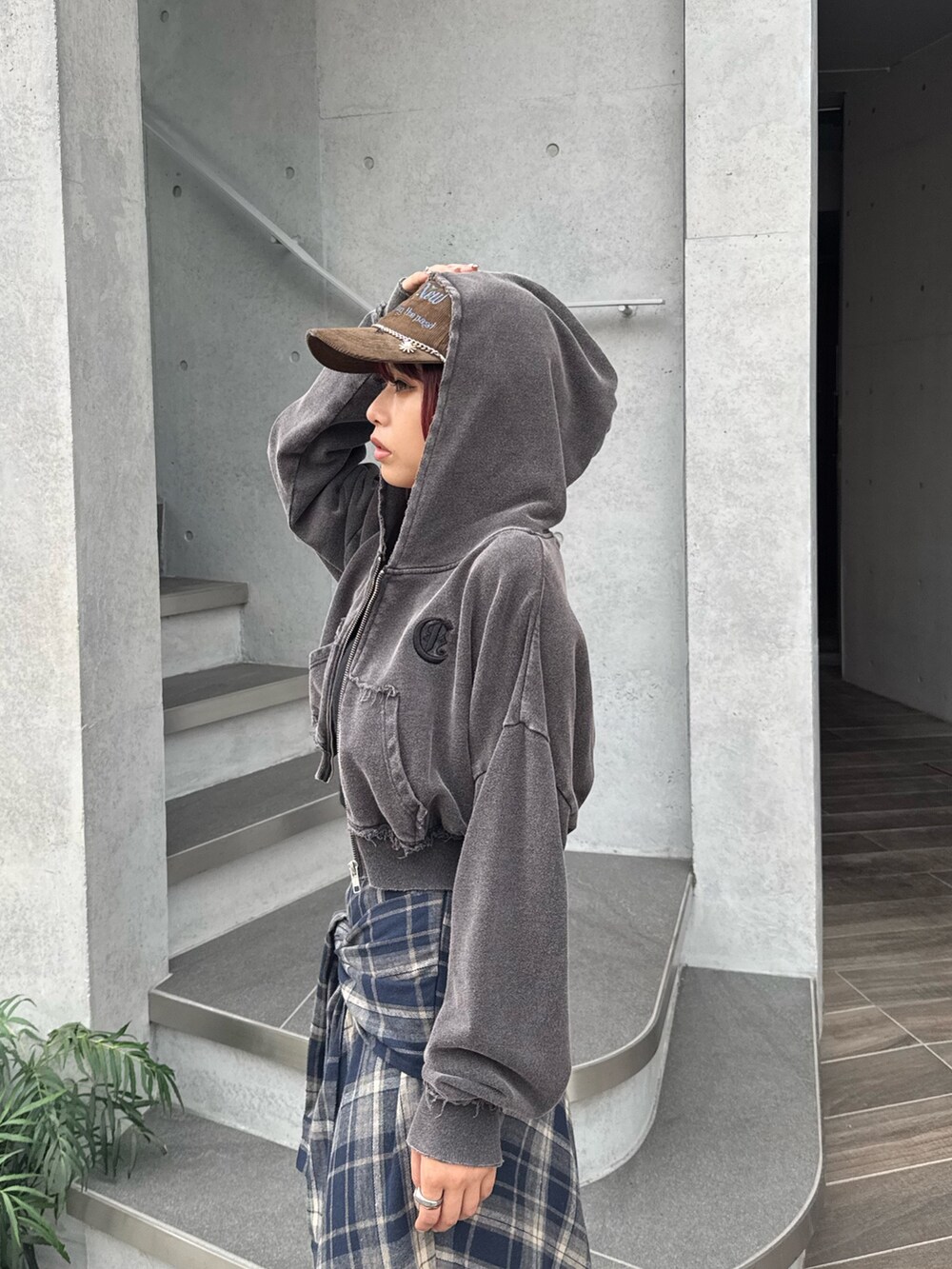 ブルー系のスカート、ブラック系のニット/セーター、ブラック系のブーツを着用したレディースの秋コーディネートの4枚目の写真