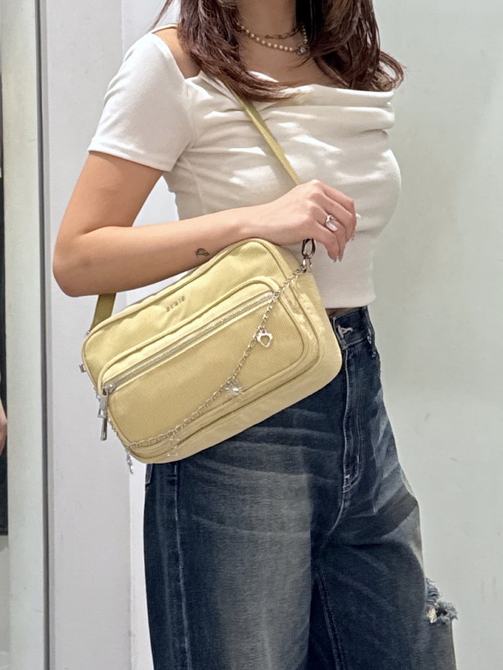ホワイト系のTシャツ/カットソー、ブルー系のデニムパンツ、イエロー系のハンドバッグを着用したレディースの夏コーディネートの5枚目の写真