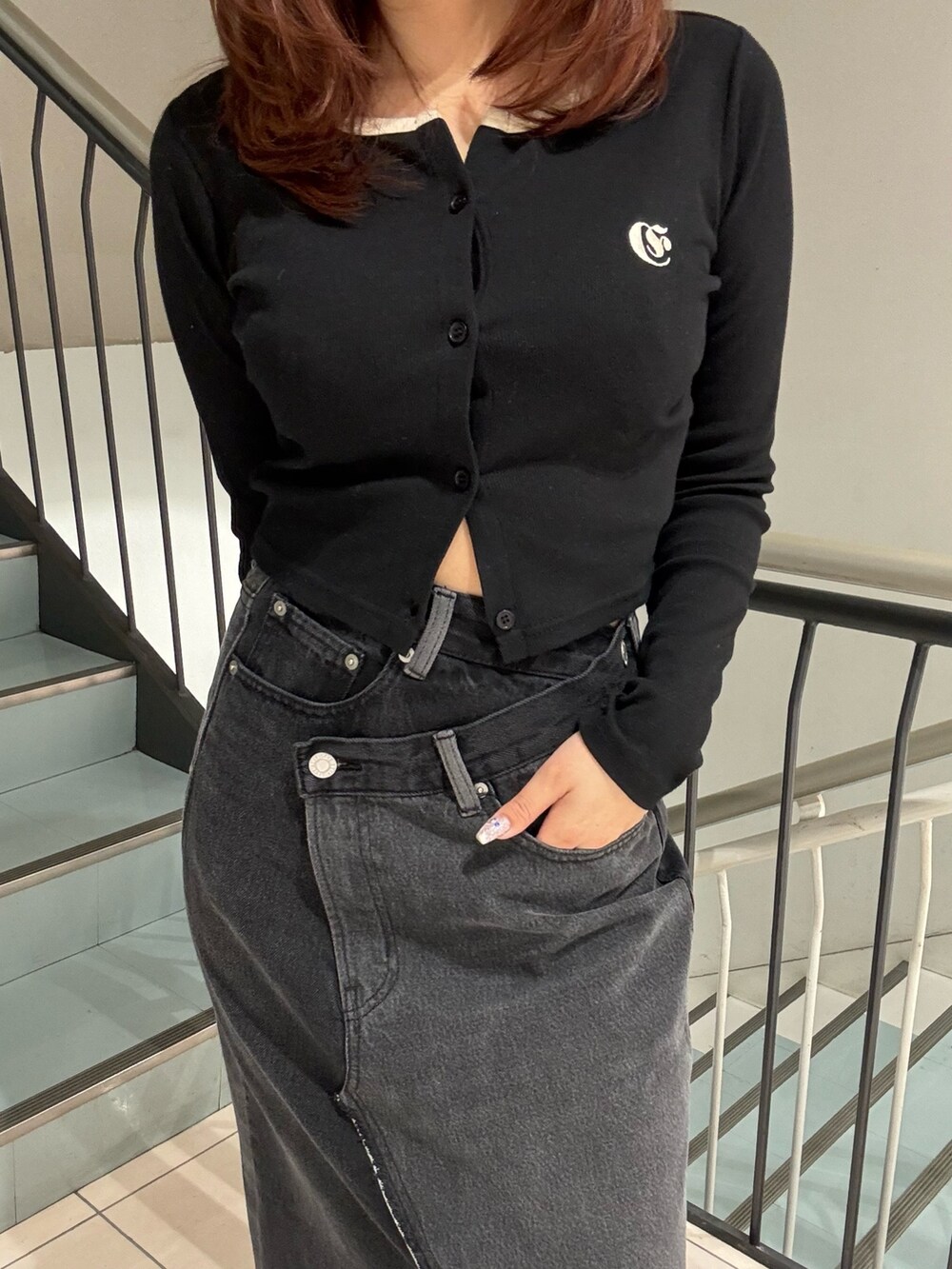 ブラック系のTシャツ/カットソー、ブラック系のデニムスカートを着用したレディースの冬コーディネートの5枚目の写真