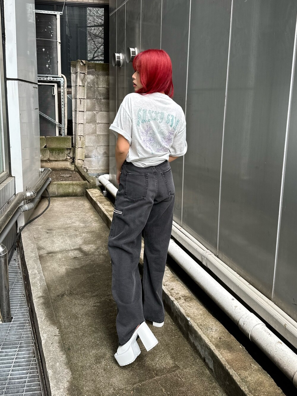 グレー系のTシャツ/カットソー、ブラック系のデニムパンツ、ホワイト系のサンダルを着用したレディースの春コーディネートの2枚目の写真