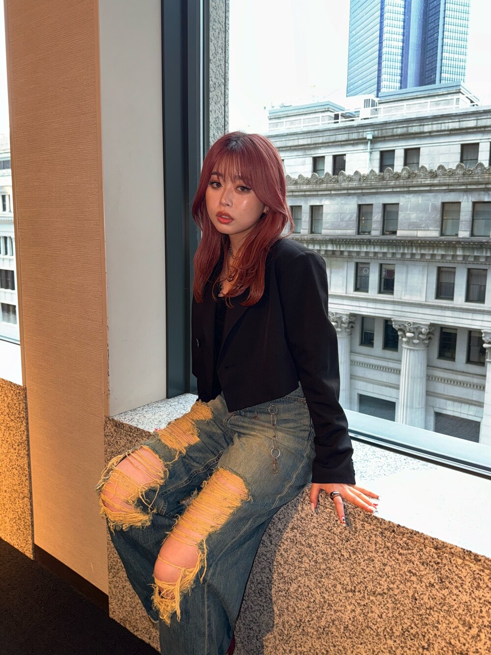 ブラック系のキャミソール、ブラック系のテーラードジャケット、ブルー系のデニムパンツを着用したレディースの夏コーディネートの2枚目の写真