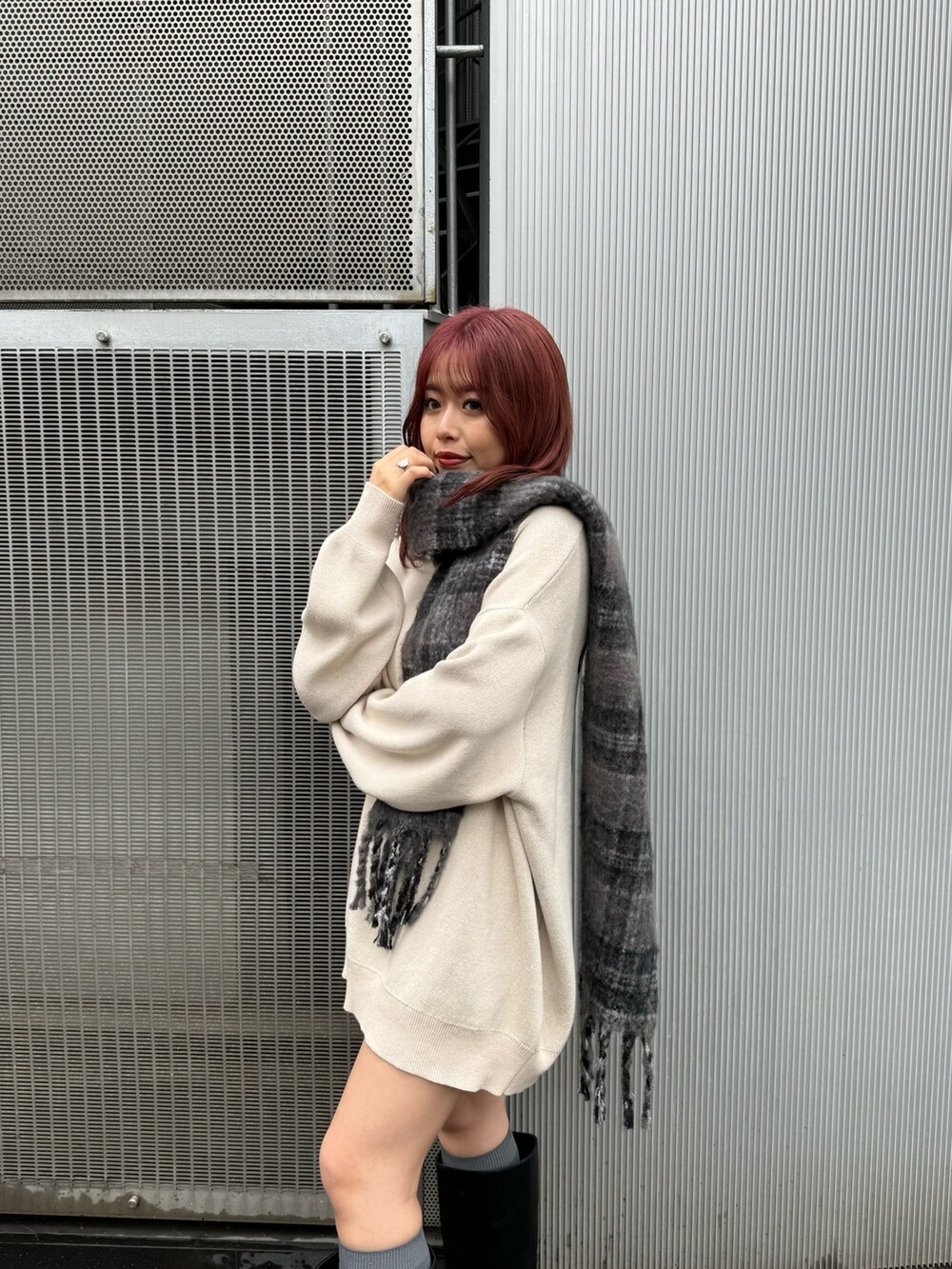 ホワイト系のニット/セーター、ブラック系のブーツ、グレー系のマフラーを着用したレディースの秋コーディネートの4枚目の写真