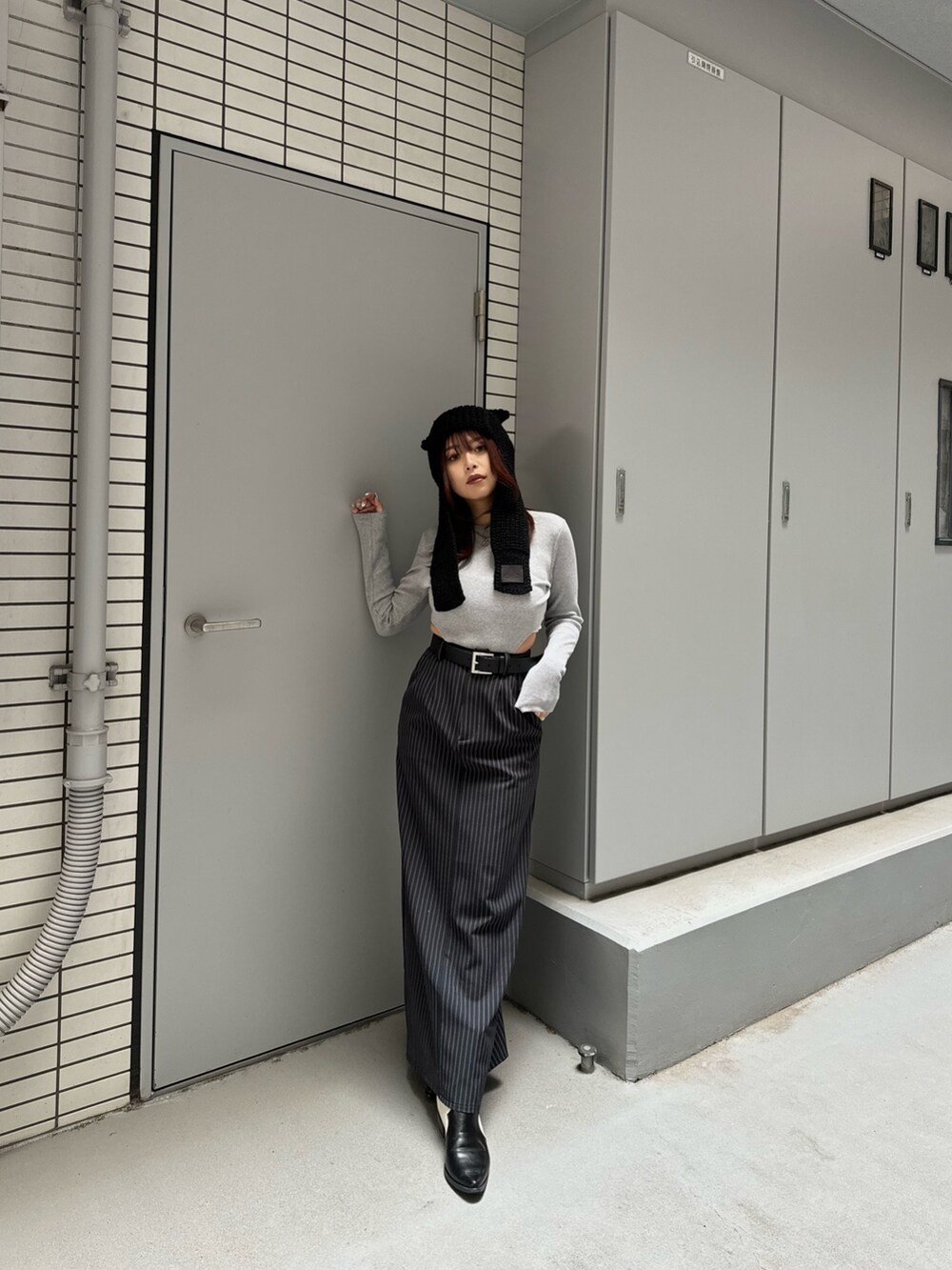 グレー系のTシャツ/カットソー、ブラック系のスカートを着用したレディースの冬コーディネートの3枚目の写真