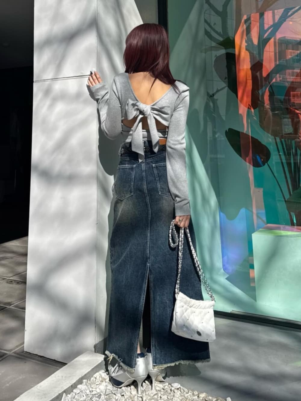 シルバー系のパンプス、ブルー系のデニムスカート、グレー系のTシャツ/カットソーを着用したレディースの春コーディネートの3枚目の写真