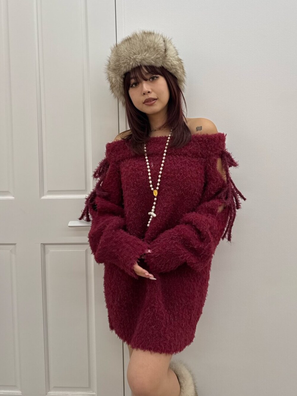 レッド系のワンピース、ベージュ系のキャップを着用したレディースの冬コーディネートの4枚目の写真