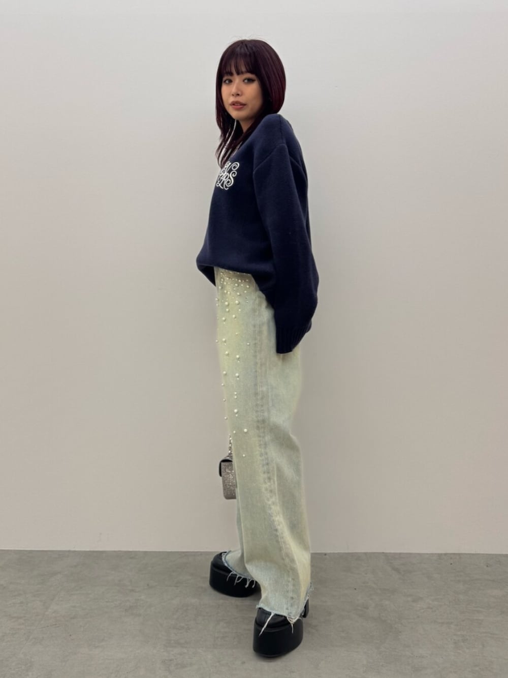 ブラック系のブーツ、ブルー系のニット/セーター、ブルー系のデニムパンツを着用したレディースの冬コーディネートの2枚目の写真