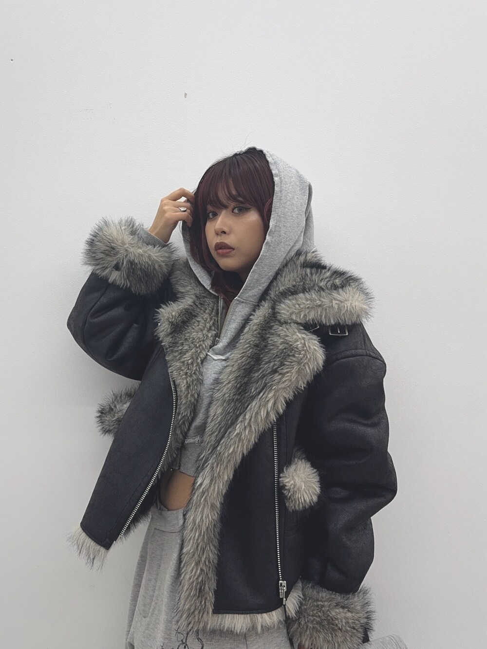 グレー系のパーカー、ブラック系のブルゾン、グレー系のスウェットパンツを着用したレディースの秋コーディネートの5枚目の写真