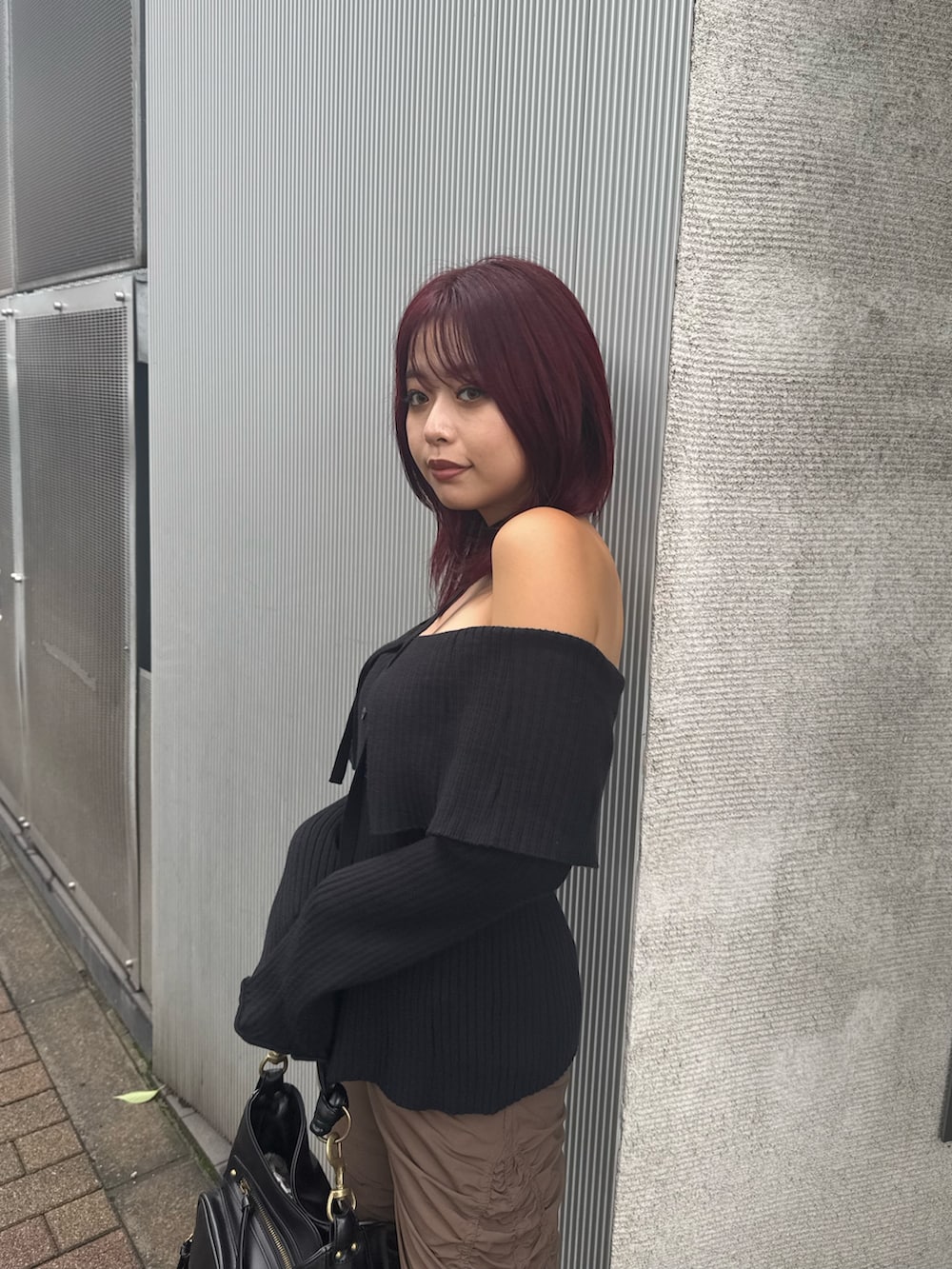 ブラック系のニット/セーター、ブラウン系のその他パンツ、ブラック系のハンドバッグを着用したレディースの夏コーディネートの5枚目の写真