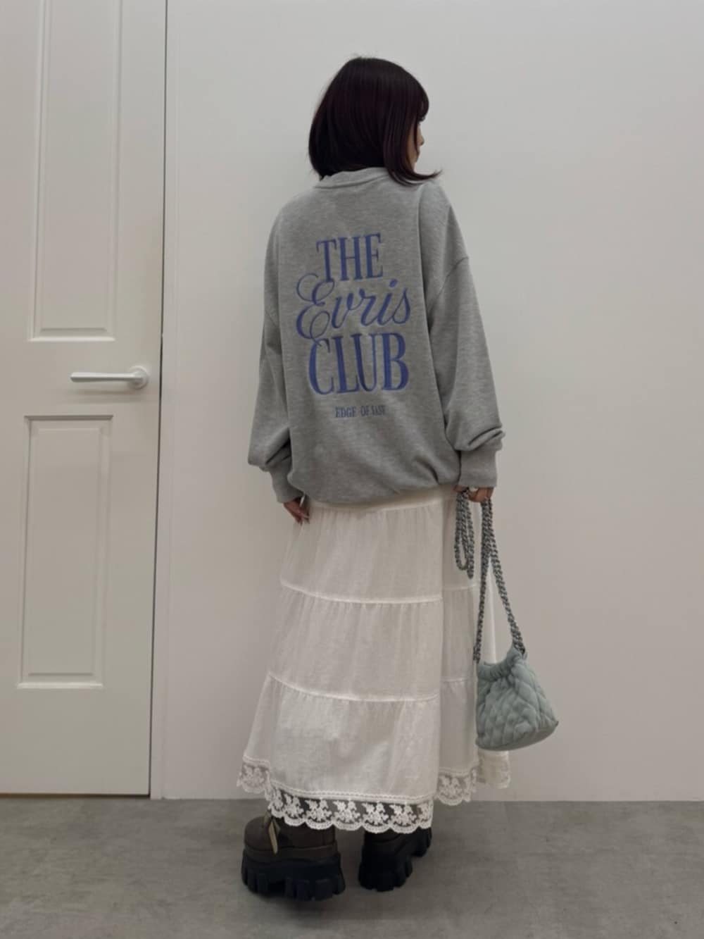 ブラウン系のブーツ、グレー系のスウェット、ホワイト系のスカートを着用したレディースの冬コーディネートの3枚目の写真