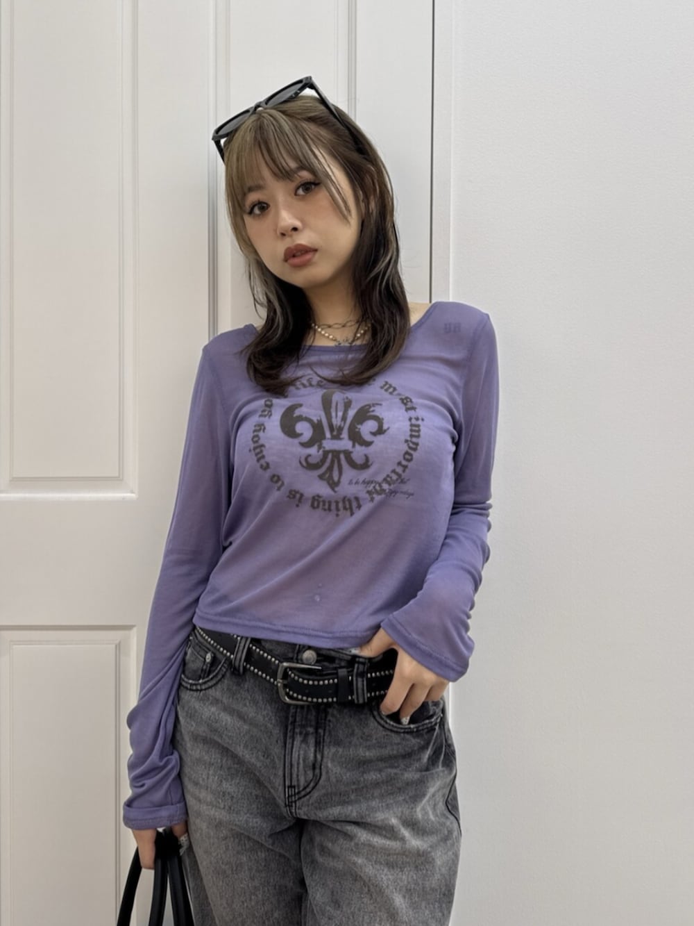 ブラック系のデニムパンツ、パープル系のTシャツ/カットソー、ブラック系のボストンバッグを着用したレディースの夏コーディネートの4枚目の写真