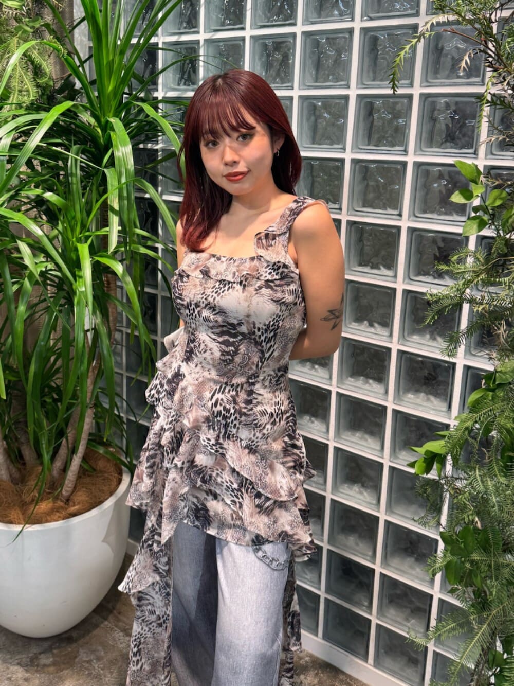 ベージュ系のワンピース、ブルー系のデニムパンツ、ホワイト系のサンダルを着用したレディースの春コーディネートの4枚目の写真